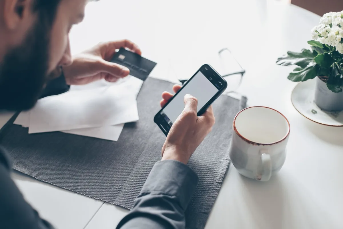 Man in Canada reviewing bills on his phone after a small instant loan