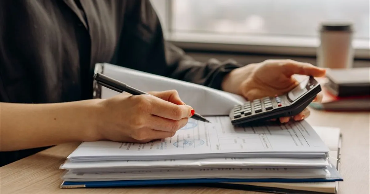 Completing a bad credit loan application with a phone and notebook