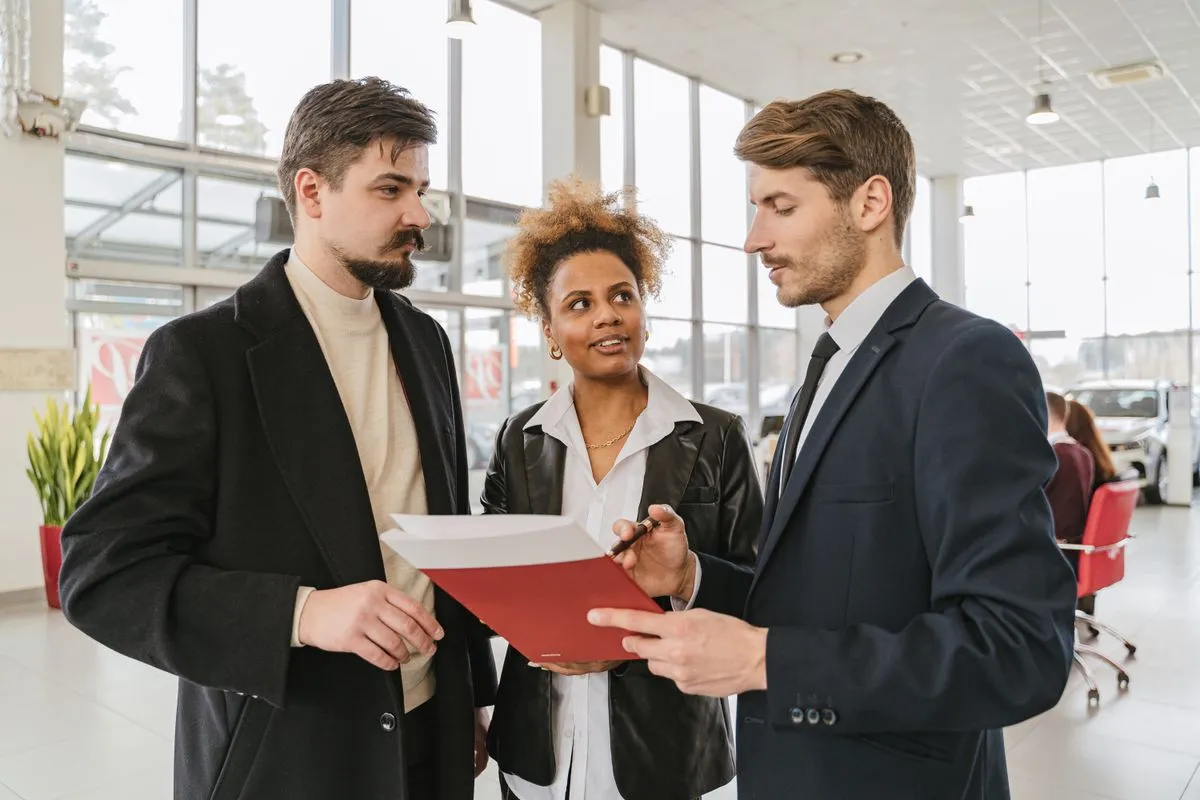 Couple discussing co-signing a car loan agreement with a dealer
