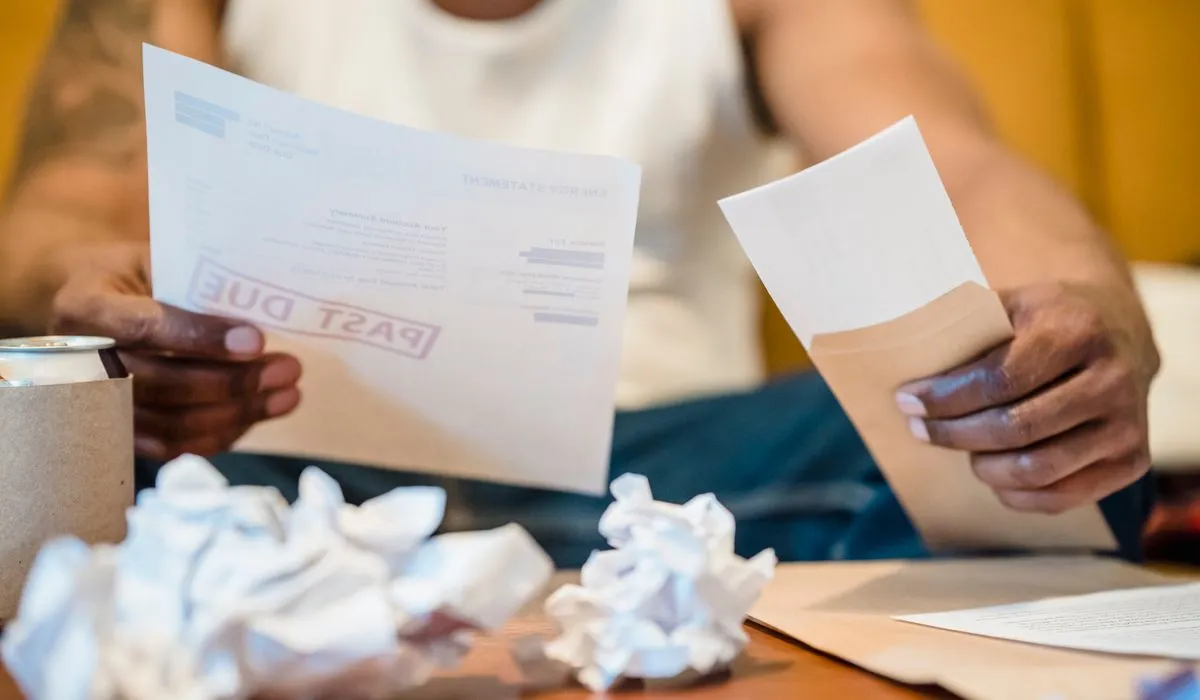 Person sorting past-due bills before debt consolidation in Canada