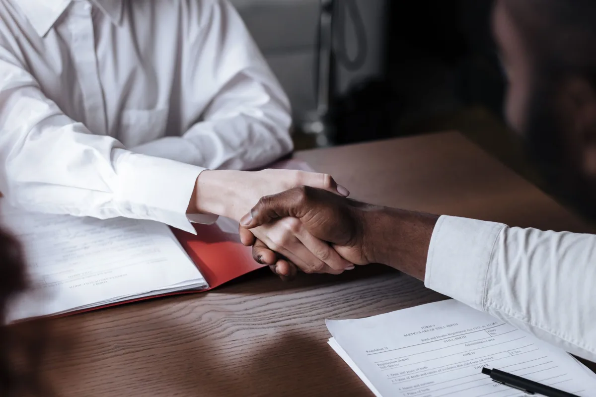 Handshake over documents finalizing a guarantor loan agreement in Canada