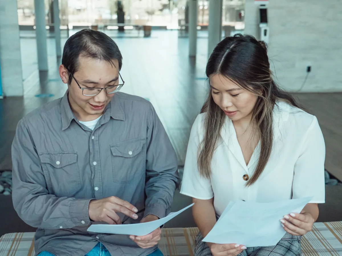 Two people reviewing documents for a guarantor loan application in Canada