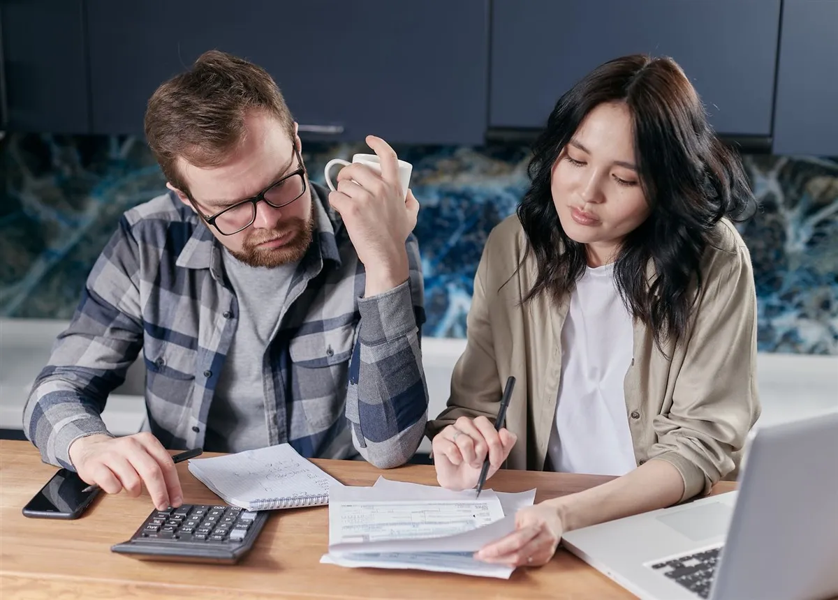 Couple comparing high-interest savings accounts in Canada at their kitchen table