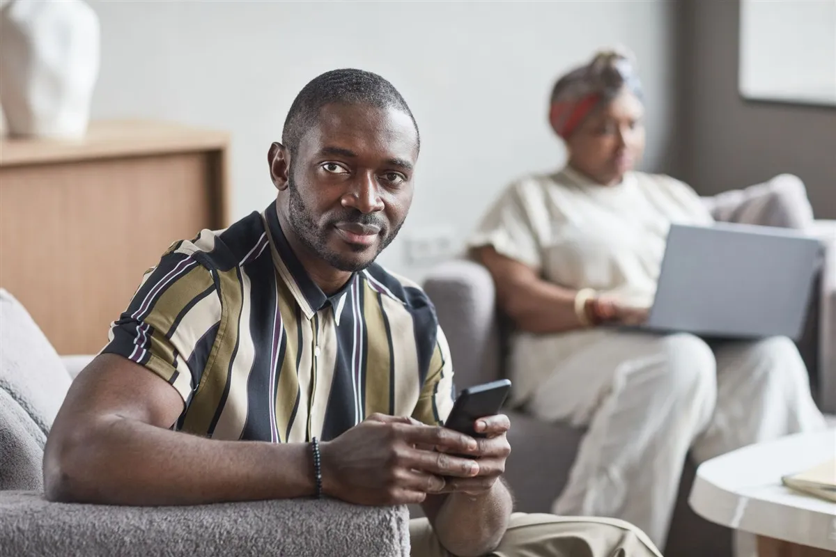 Man getting a loan 24/7 approval on his phone at home in Canada