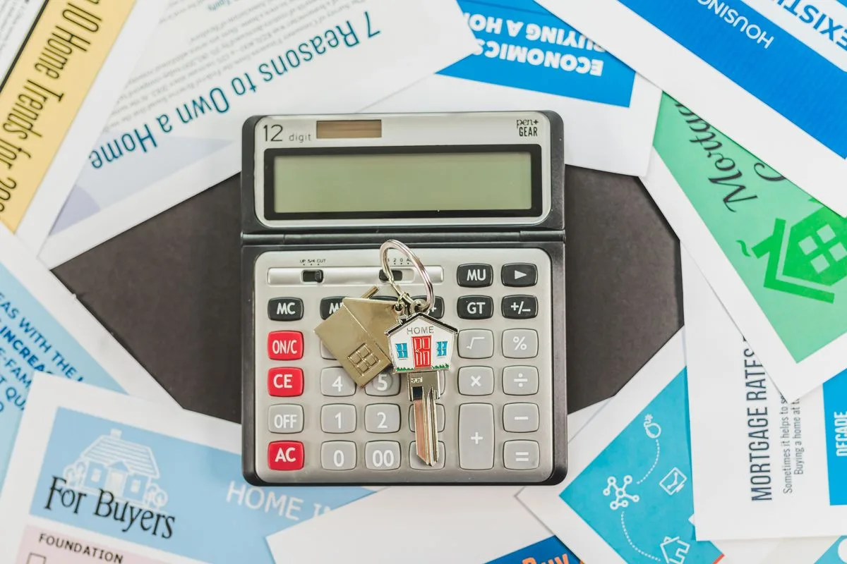 Mortgage documents checklist with a calculator and house keys