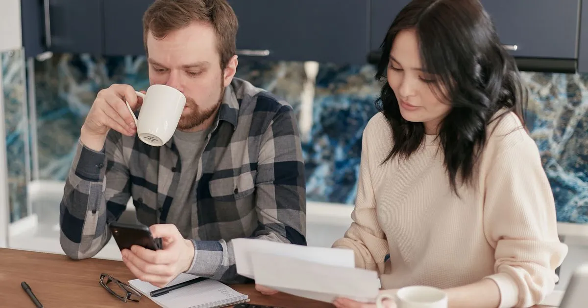 Couple planning their budget and micro loan repayment at their kitchen table in Canada