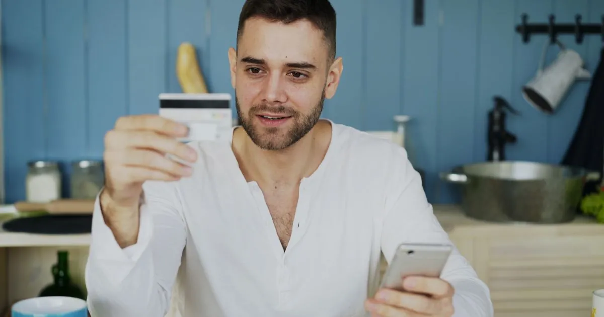 Freedom 500 loans review - borrower checking the lender's published terms on his phone at home