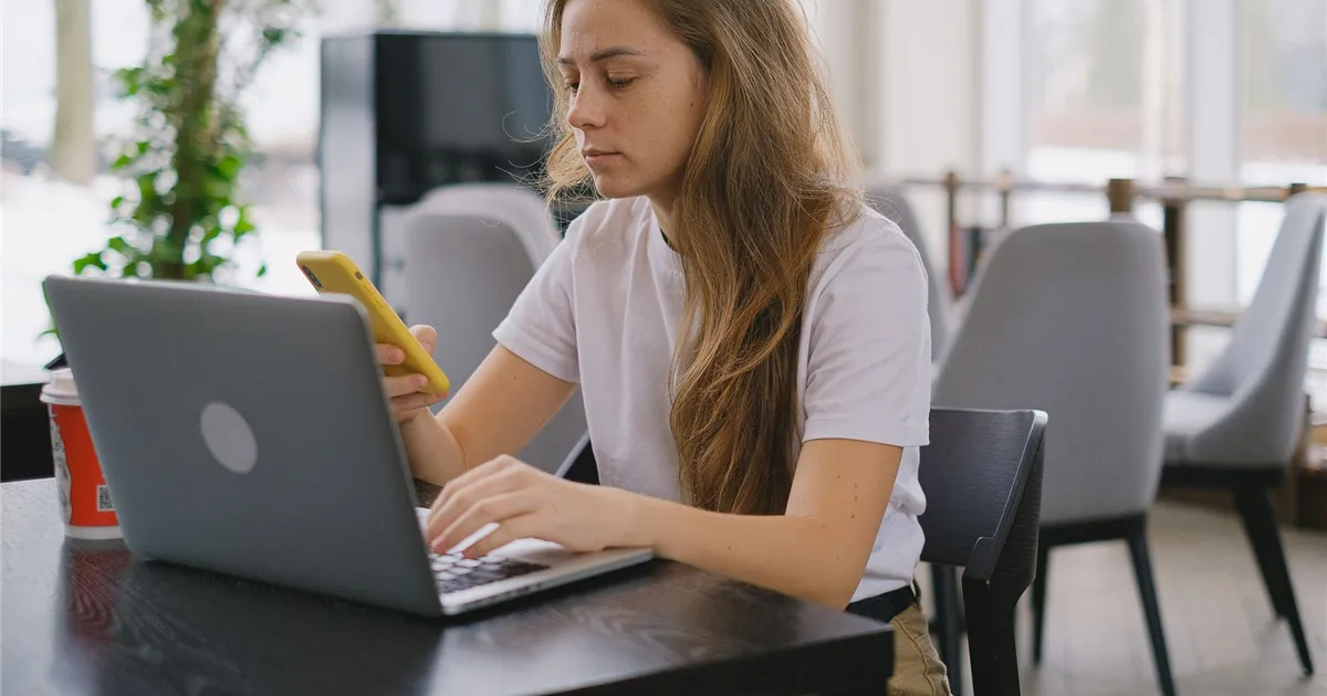 Loan apps Canada - borrower applying for an online loan from a phone beside a laptop