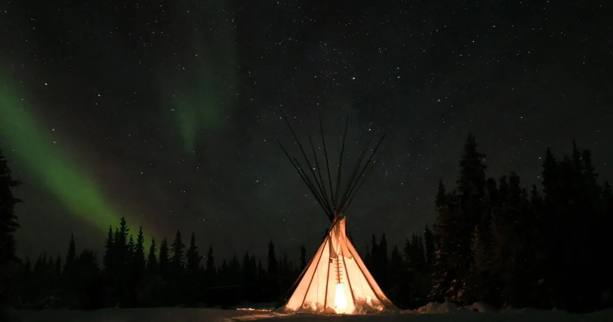 No credit check loans Northwest Territories - a glowing tipi under the aurora near Yellowknife