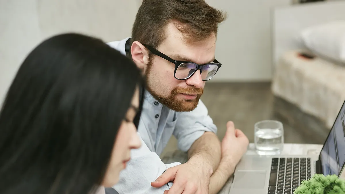 Couple comparing personal loans offers side by side on a laptop